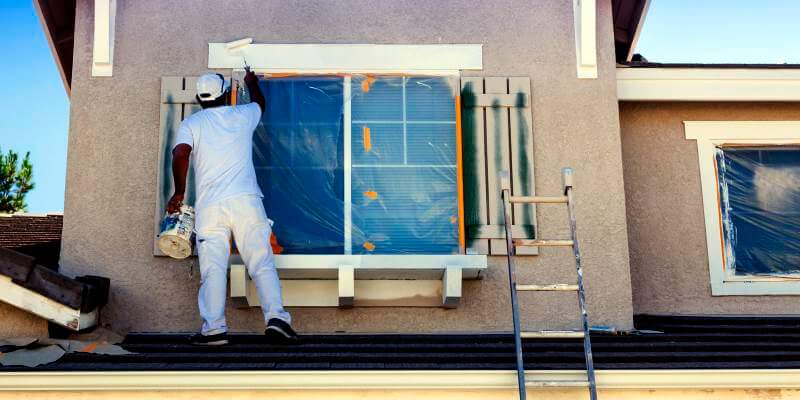 House Painter Painting the Trim and Home Exterior
