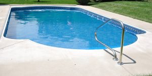 inground swimming pool with patio and stairs