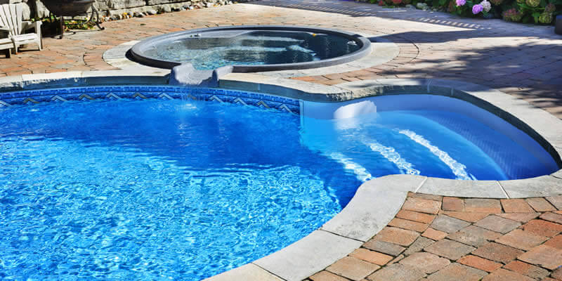 new swimming pool with hottub and brick patio