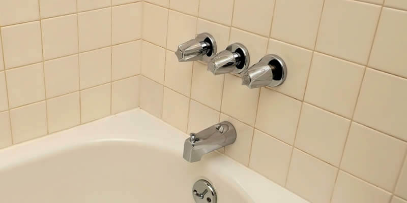 old 3-knob bathtub faucet and tub spout