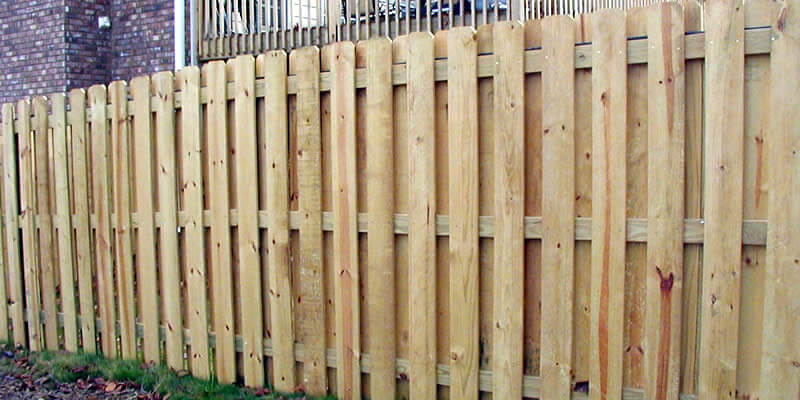 natural finish shadowbox fence installed around home