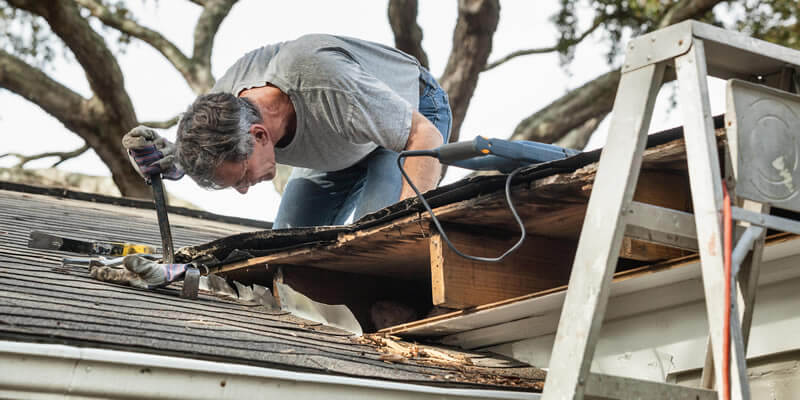 man on roof repairing a leak