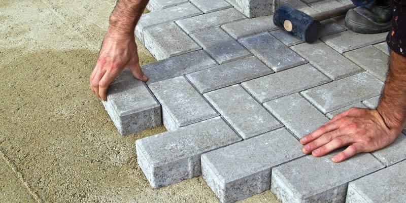 worker installing brick pavers