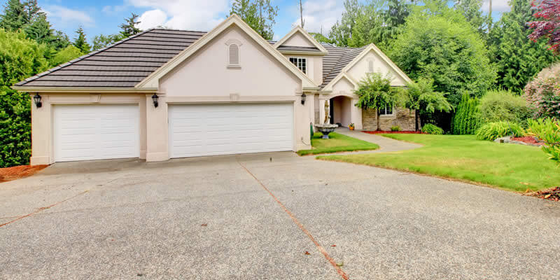 nice home with concrete driveway in need of maintenance