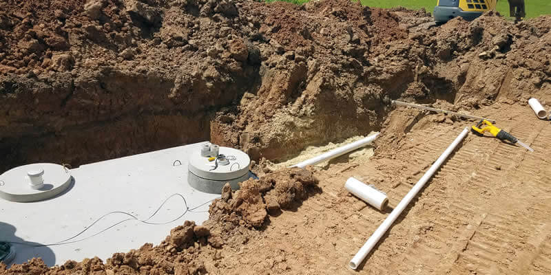 concrete septic tank being installed in yard