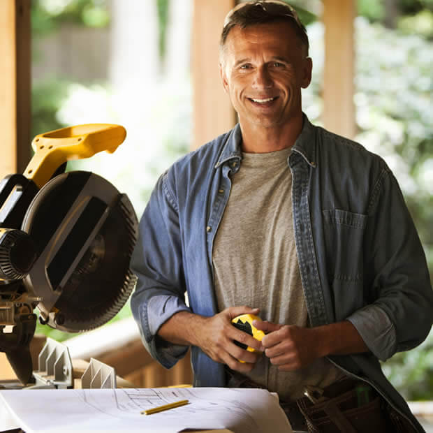 carpenter smiling while at saw