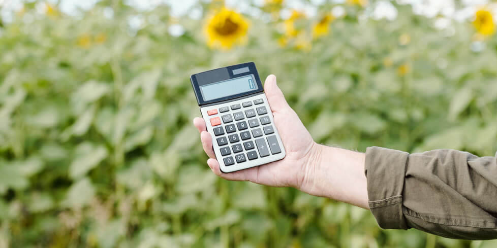 man holding calculator in his flower field